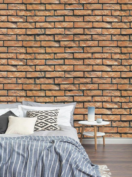 a bed sitting in front of a brick wall 