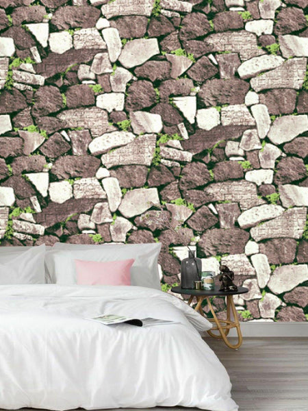 a bed with white sheets and a stone wall 